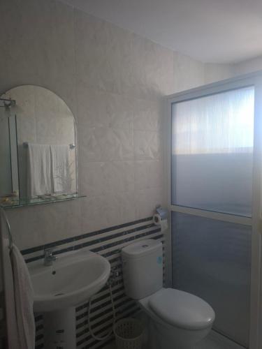 a bathroom with a toilet and a sink and a mirror at Hotel Rama in Oued Laou