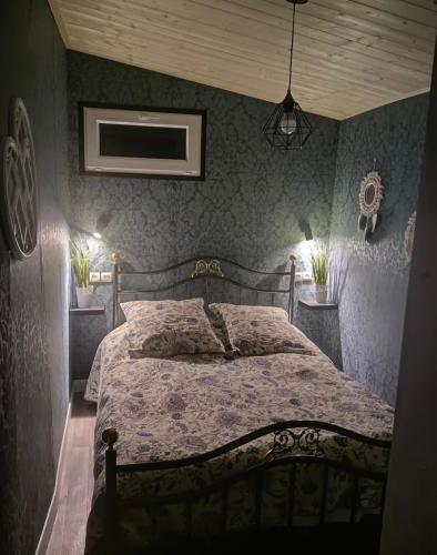 a bedroom with a large bed with blue walls at L Empreinte in Saint-Juvin