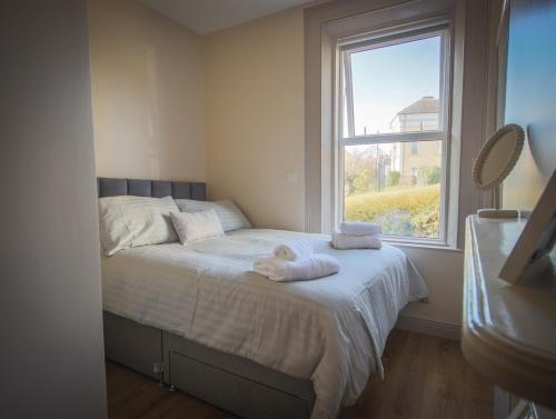 a bedroom with a bed with towels on it at East Bridge House in Enniskillen