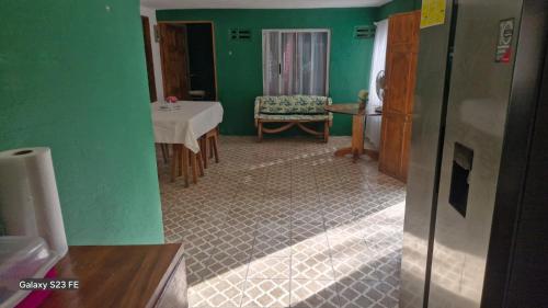 a green room with a table and a chair at Chemas alojamiento in Pochote