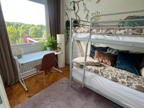 ein Schlafzimmer mit Etagenbetten, einem Schreibtisch und einem Fenster in der Unterkunft Båt huset in Halmstad