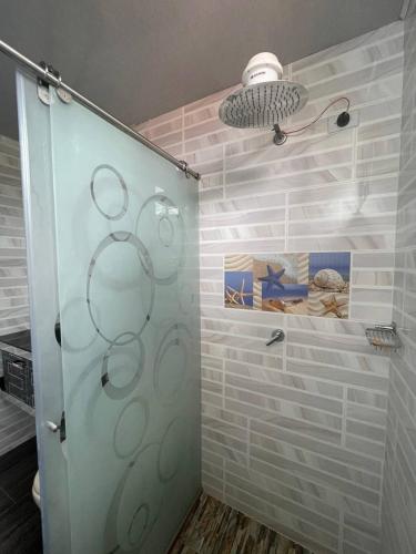 a shower with a glass door in a bathroom at Valso Posada Campestre in Silvania