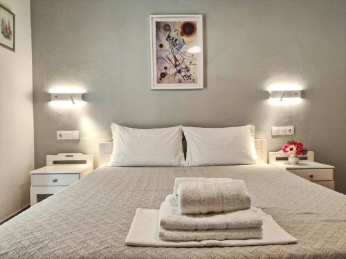 a bedroom with a white bed with towels on it at Apartments Papadioti in Pefki