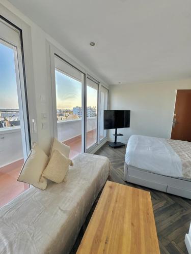 a bedroom with a large bed and large windows at Chez Lima in Lorient