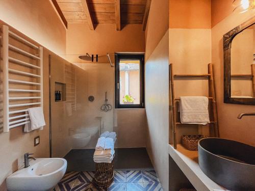 a bathroom with a sink and a tub and a toilet at Ca' Bella Hospitality in Vignole Borbera