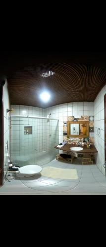 a bathroom with two sinks and a glass wall at Casa Maravilha in Aquiraz