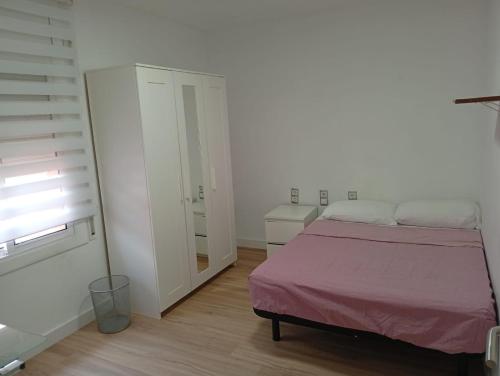 a white bedroom with a bed and a closet at Imperial Tarraco Apartment in Tarragona
