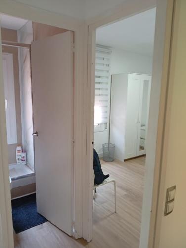 an open door to a room with a chair and a bedroom at Imperial Tarraco Apartment in Tarragona