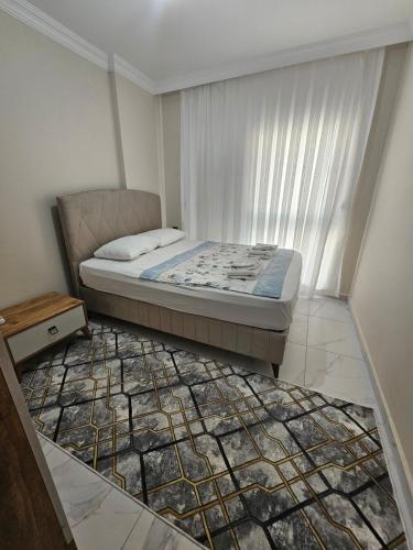 a bedroom with a bed and a rug at Daire 1 in Gazipasa