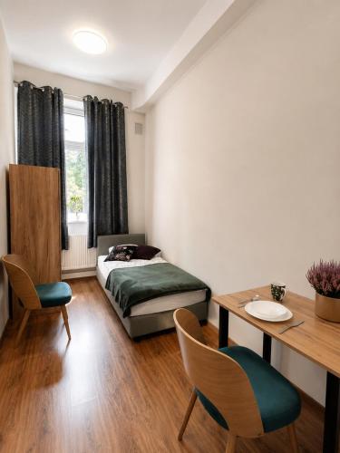 a bedroom with a bed and a table and chairs at Hostel KASZUBSKA in Wrocław