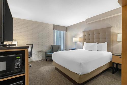 a hotel room with a bed and a television at Drury Inn & Suites Joplin in Joplin