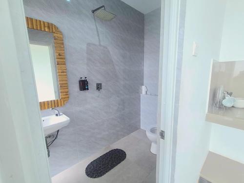 a bathroom with a sink and a toilet and a mirror at Altura Esthetic Villas in Bokor