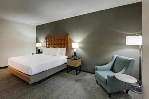 a hotel room with a bed and a chair at Drury Inn & Suites Montgomery in Montgomery