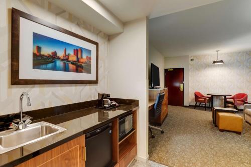 a kitchen with a sink and a living room at Drury Plaza Hotel Columbus Downtown in Columbus