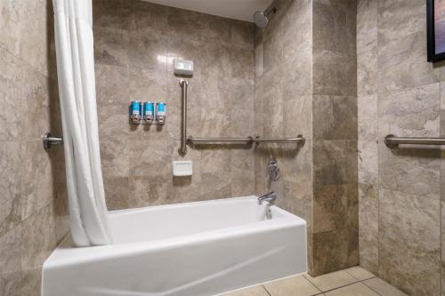 a bathroom with a white tub and a shower at Drury Plaza Hotel New Orleans in New Orleans