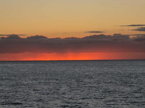 a sunset over the ocean with the sky at Playa de Mogán in Playa del Cura