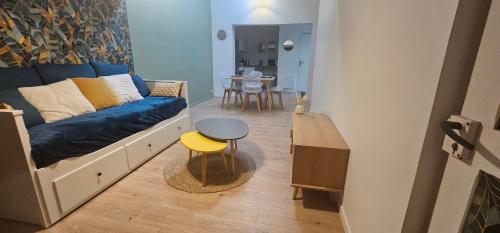 a living room with a blue couch and a table at La mie du Hom in Thury-Harcourt