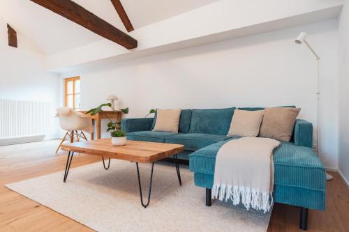 a living room with a blue couch and a table at Krebiehls Winkelhof in Herxheim am Berg