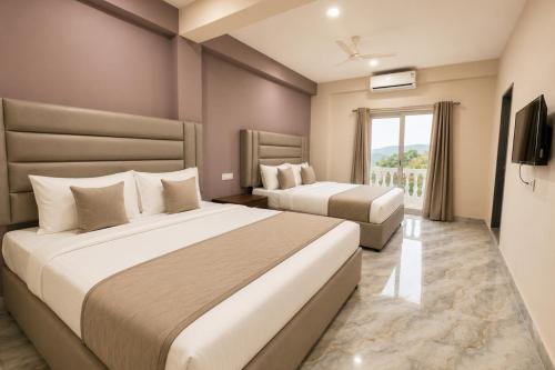 a hotel room with two beds and a window at Home Stay CampoDeVista in Calangute