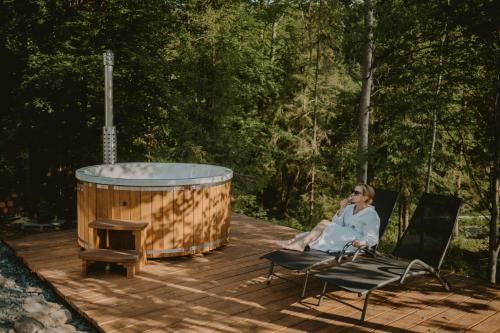 a woman sitting on a chair next to a hot tub at Malinova 36 in Wisła
