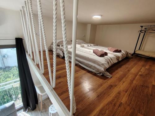 a bedroom with a bed in a room with wooden floors at 2 1D2 Mini Condos- Large Studio SW facing in Tivat