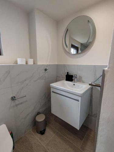 a white bathroom with a sink and a mirror at 2 1D2 Mini Condos- Large Studio SW facing in Tivat