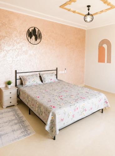 a bedroom with a large bed with a pink wall at appartement in Oujda