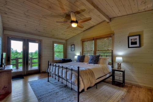 a bedroom with a bed and a ceiling fan at Oscars Outpost Fire Pit Pet Friendly in Mineral Bluff
