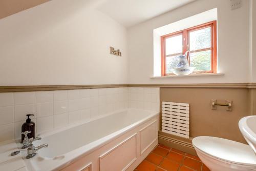a bathroom with a tub and a toilet and a window at 1 Bed in Richmond oc-44401 in Reeth