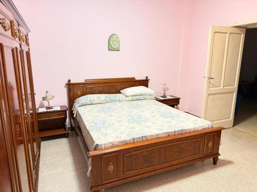 a bedroom with a wooden bed and two night stands at Agriturismo Siviglia in Tocci
