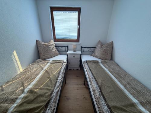 two beds in a small room with a window at Landhaus Settin 