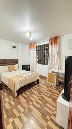 a bedroom with two beds and a television in it at Hospedaje Ariana in Supe