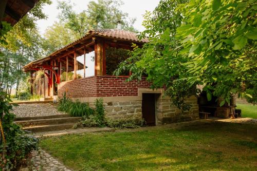 a brick building with a porch and stairs in a yard at Izletište Ružić in Mrčajevci