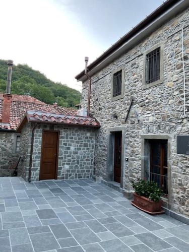 a stone building with two doors and a patio at Casa Il Borgo 1 in Tavernelle