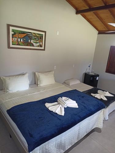 a bedroom with a bed with two towels on it at Chalé caminho das cachoeiras in São Thomé das Letras