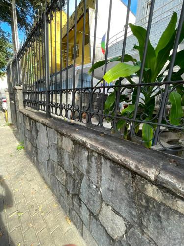 a fence on a brick wall with a plant at Casa Art Maison Recife in Recife
