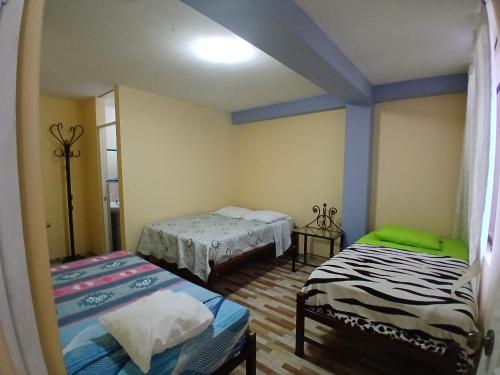 a room with two beds in a room at Hospedaje Vicente in Lunahuaná