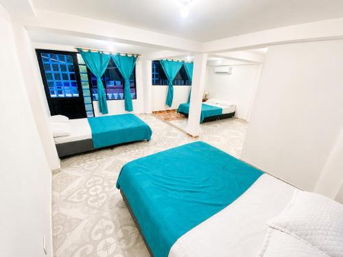 a bedroom with two beds and two windows at El Bosque in Nocaima