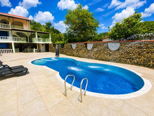 a large blue swimming pool in front of a house at El Bosque in Nocaima
