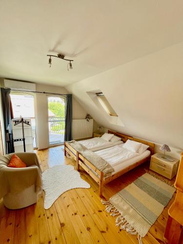 a bedroom with a bed and a chair in it at Pelso apartman in Balatonalmádi