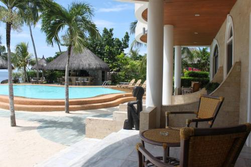 a resort with a swimming pool and palm trees at Linaw Beach Resort in Panglao Island