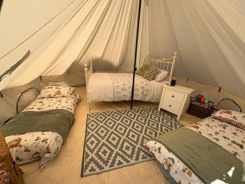 a bedroom with two beds in a tent at Rogarnet caravan park in Three Legged Cross