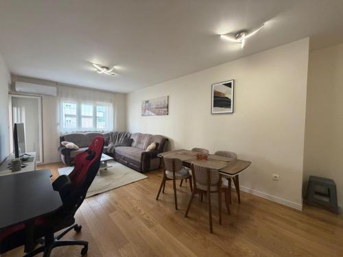 a living room with a table and a couch at Apartment Central Point - Podgorica in Podgorica