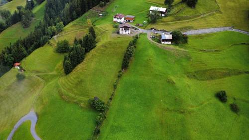 an aerial view of a house on a green hill at Freiheitsgefühl in Kaunerberg