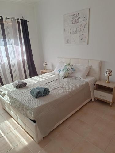a bedroom with a bed with two towels on it at Cristais do Mar in Armação de Pêra