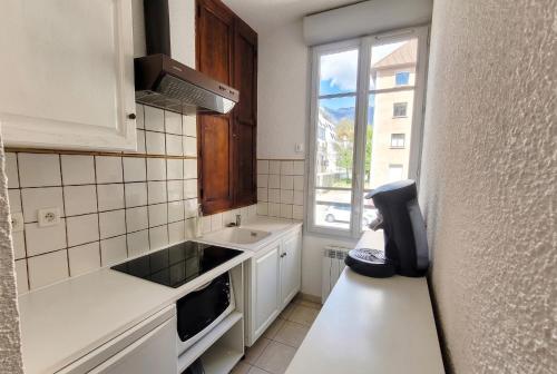 a small kitchen with a sink and a window at Gîte de La Menuiserie in Gap