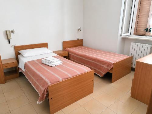 ein Hotelzimmer mit zwei Betten und einem Fenster in der Unterkunft La Colombella in Montemonaco