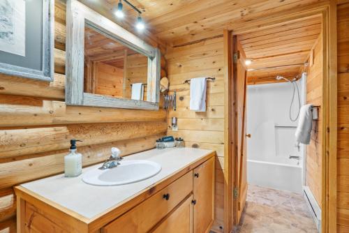 a bathroom with a sink in a wooden cabin at Henry's Lake View Cabin + BBQ + Fire Pit + Decks! in Island Park