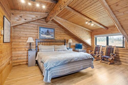 a bedroom with a bed in a log cabin at Henry's Lake View Cabin + BBQ + Fire Pit + Decks! in Island Park