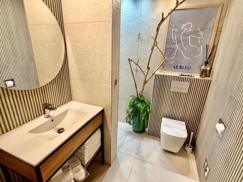 a bathroom with a sink and a mirror at ENKLAWA IMPERIUM- DOM WAKACYJNY-APARTAMENTY NAD JEZIOREM- 20 km od TORUNIA-PLAŻA,JACUZZI 